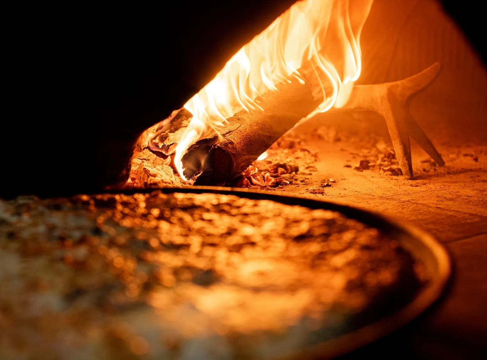 Pizza di Karma Pizza al Trancio durante la cottura nel forno a legna